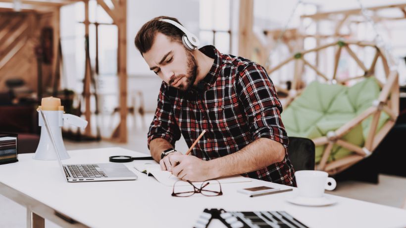 Un homme concentré dans son travail grâce à de la musique