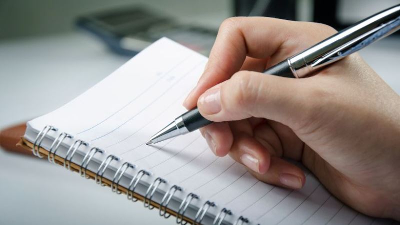 Une personne en confiance qui note ses réussites