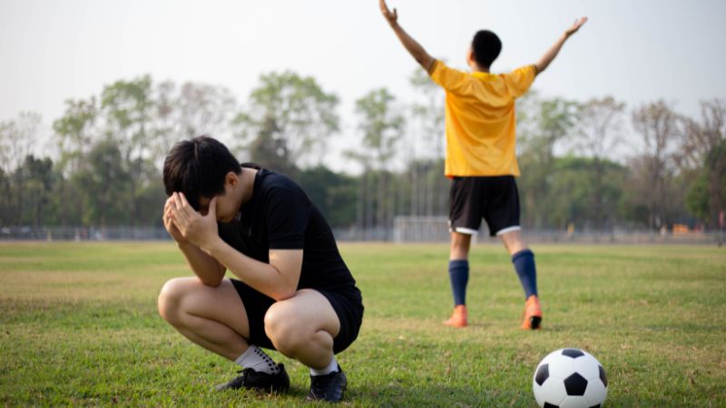 Un joueur qui vient de perdre un match de foot et qui se concentre sur sa défaite