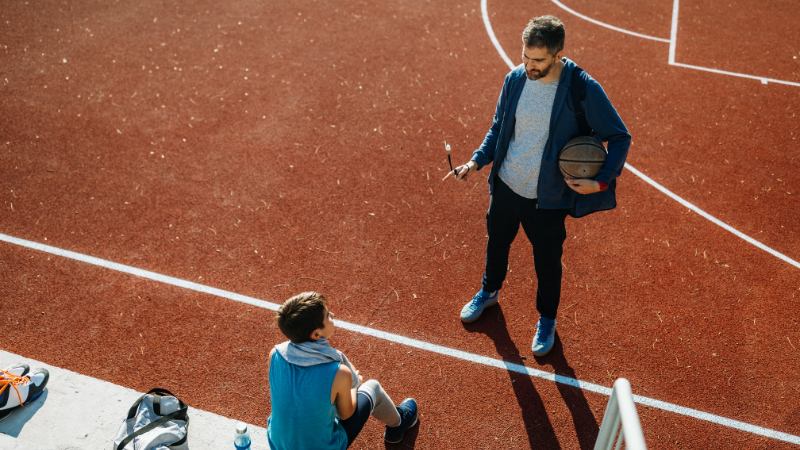Un coach qui assure la préparation mentale de son joueur de basket