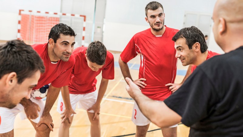 Un entraîneur en train de coacher son équipe de handball