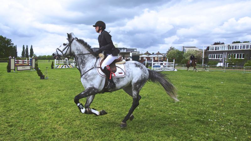 Une femme gérant parfaitement la pression grâce à une bonne préparation mentale du cavalier