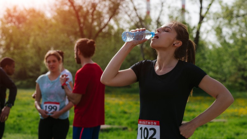 Une spécialiste de running qui boit de l'eau