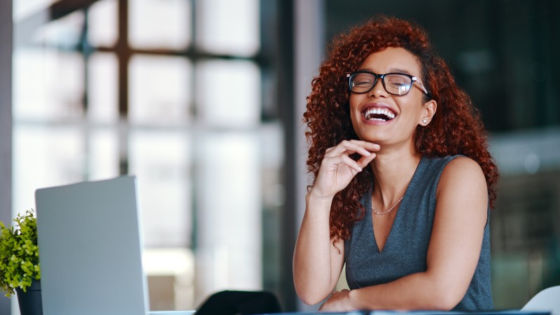 Une femme épanouie au travail grâce à un coaching professionnel