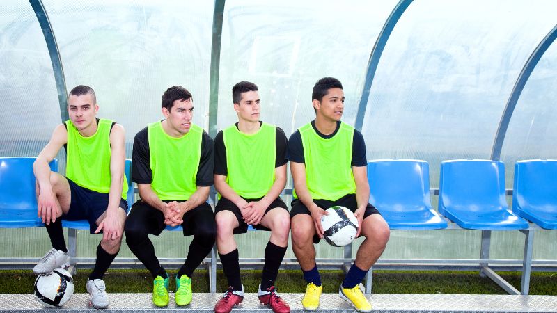 Des joueurs de foot sur le banc avec un état d'esprit de leader