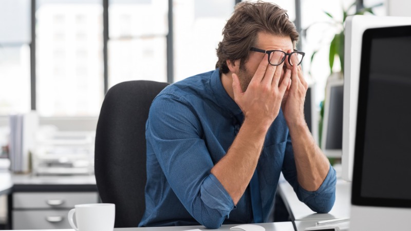 Un homme irrité au travail à cause d'un burn-out